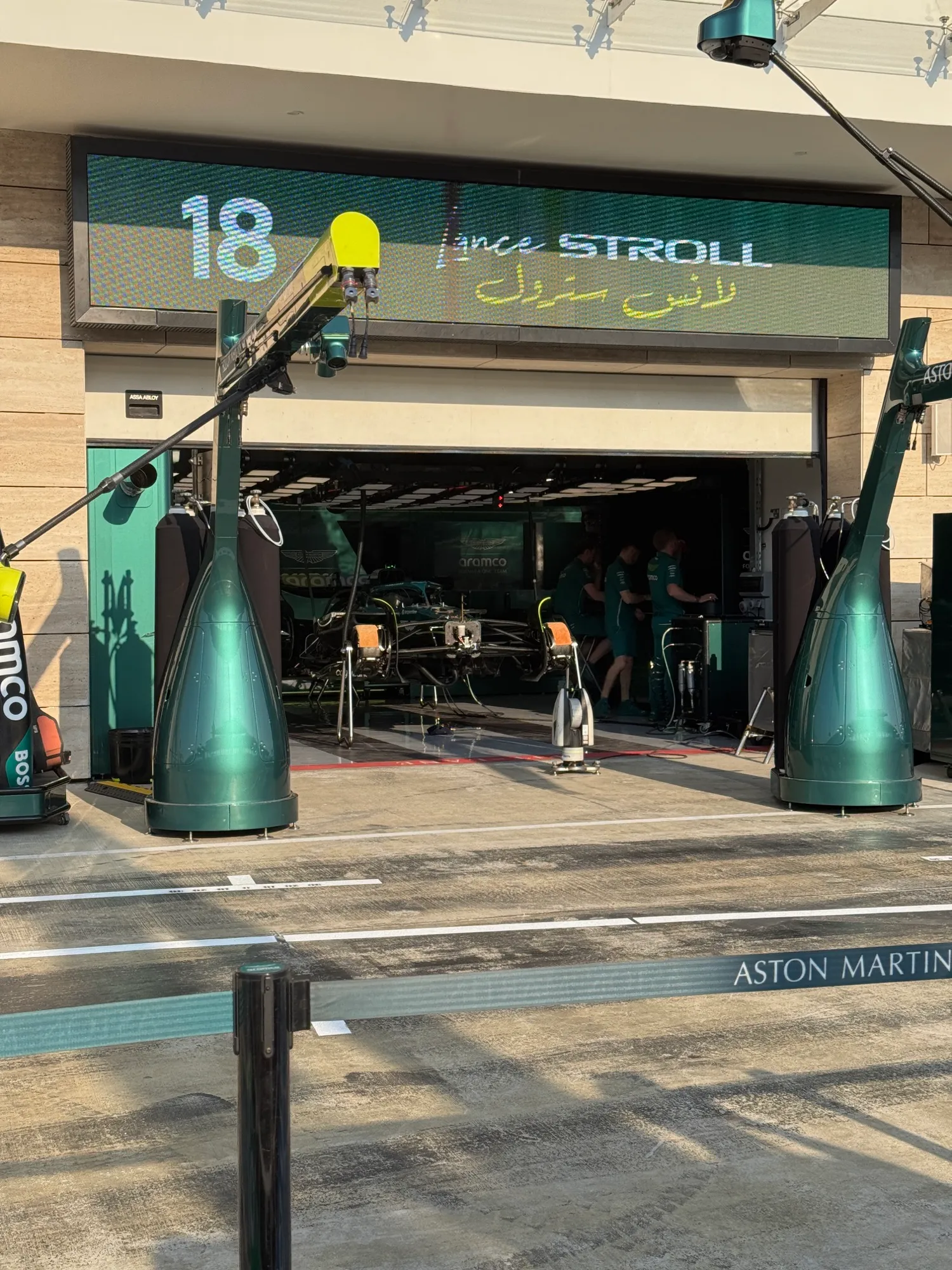lance stroll’s garage, with his name in english and arabic above the door