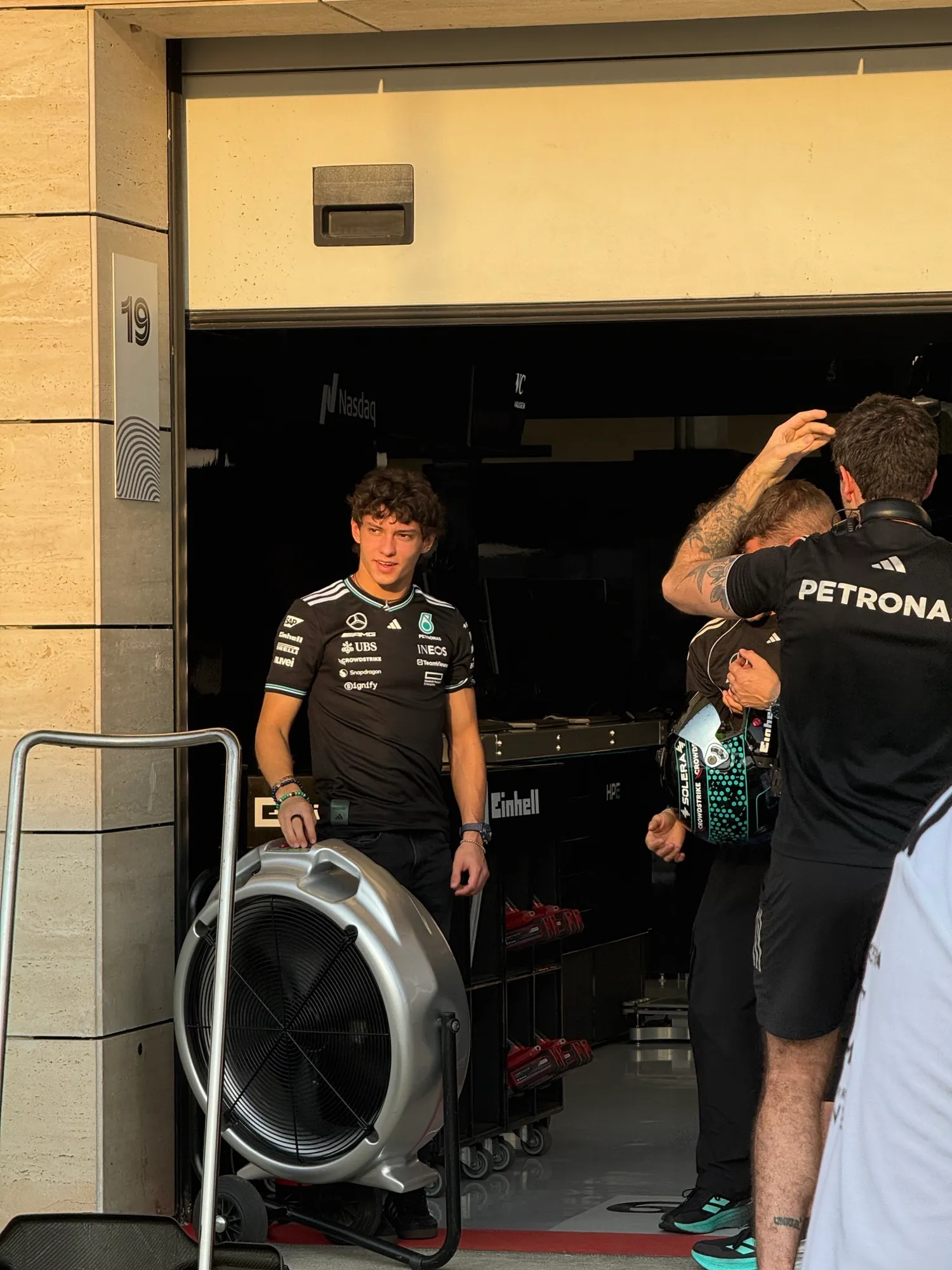 kimi antonelli standing outside the mercedes garage in team kit