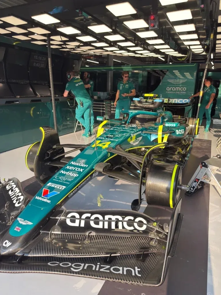 alonso’s car in the garage with mechanics behind it