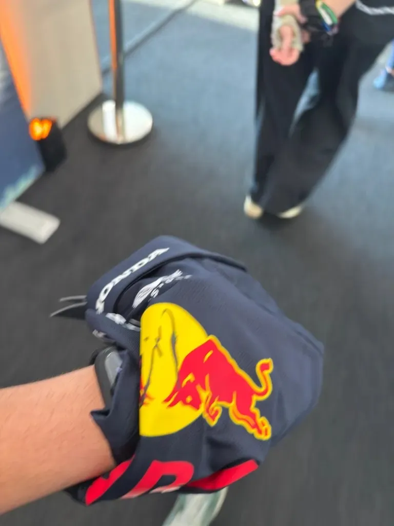 my red bull polo wrapped around my hand, with tsunoda’s signature on the logo