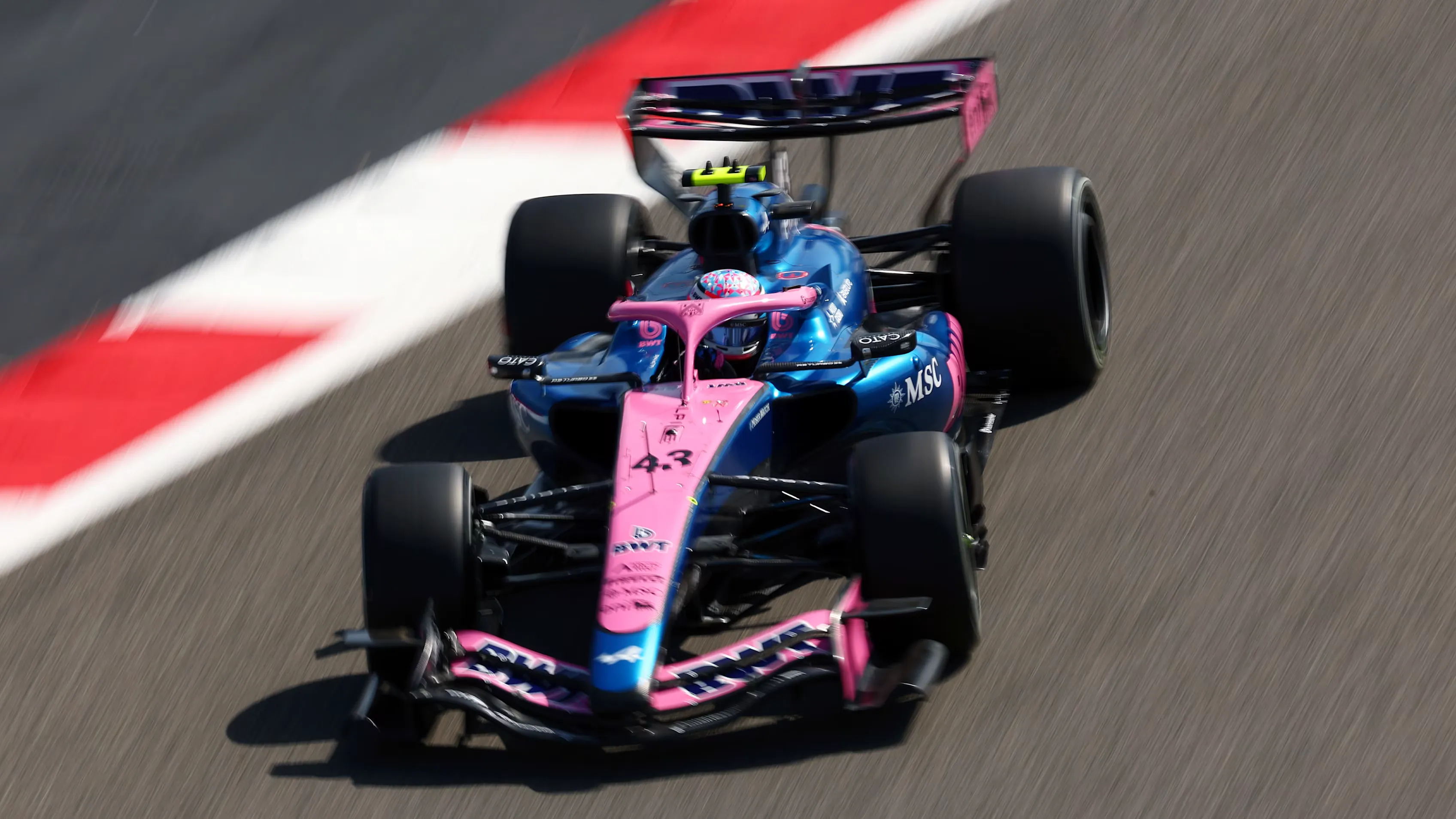 a pink and blue alpine at speed, seen from above