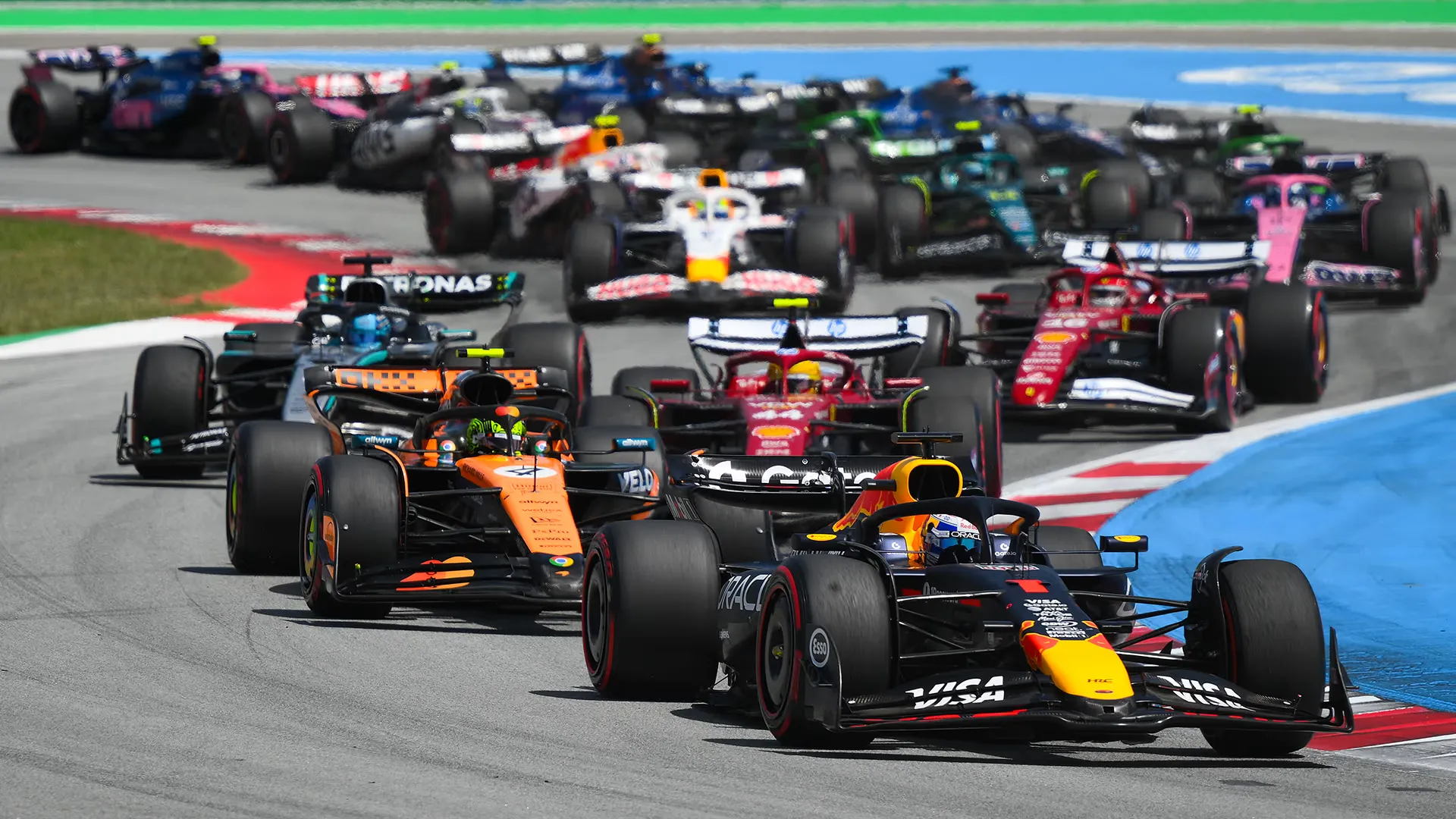 a red bull leads the pack into the first corner at the start of a race