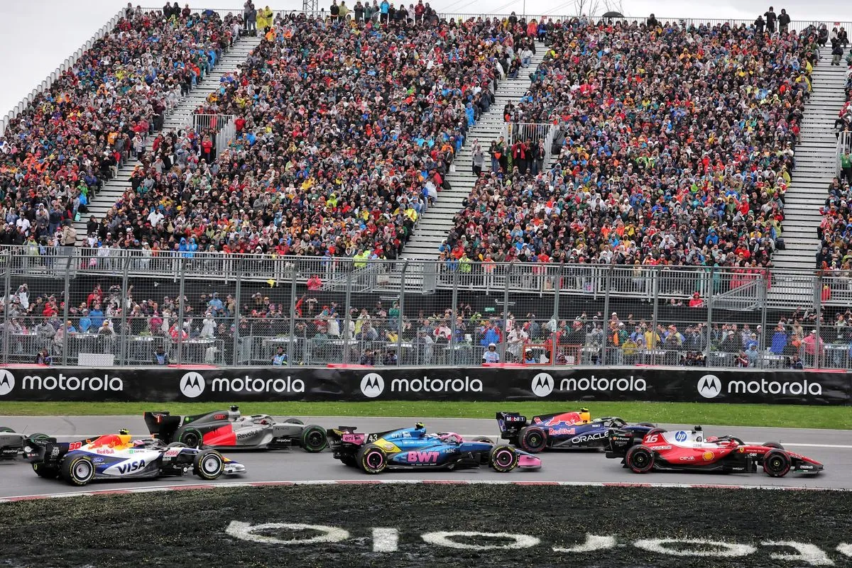 cars file past a packed grandstand in montreal