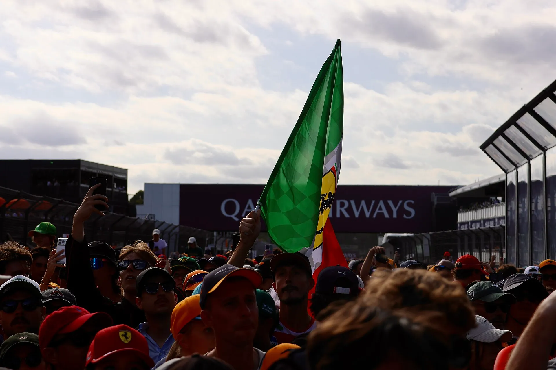 fans standing on the track after the australian grand prix, one holding up a ferrari flag